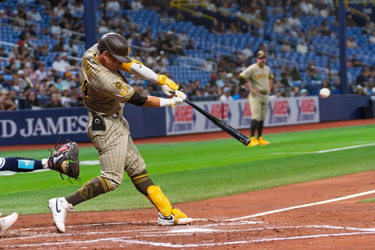 A baseball batter making contact, with the ball in flight beside the bat